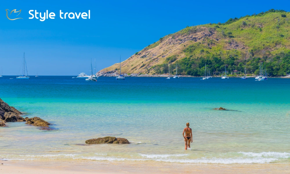 Sandy shoreline and surrounding hills at Nai Harn Beach in Phuket