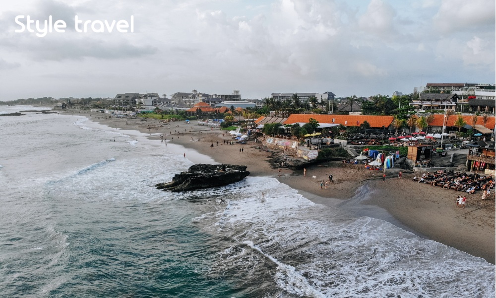 Aerial view of Canggu beach with surfers and umbrellas located in the west of Bali