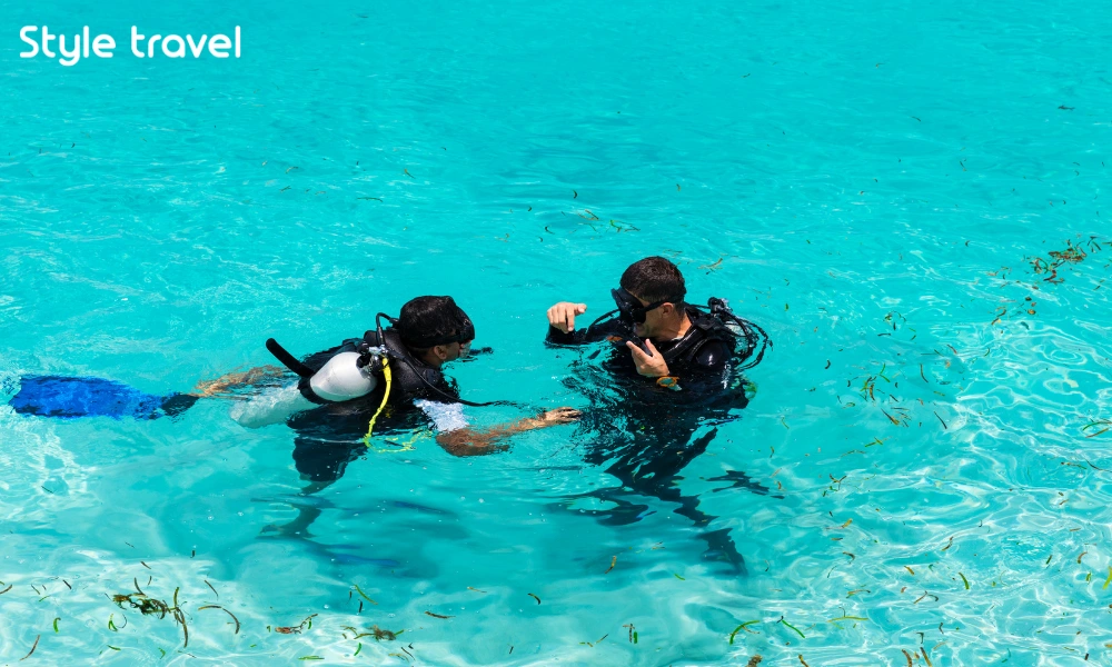 Dive instructor guiding a beginner in shallow water off Koh Tao