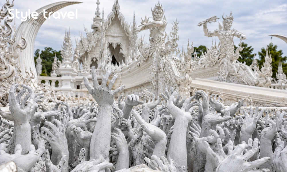 Reaching hand sculptures beside the bridge at Chiang Rai White Temple