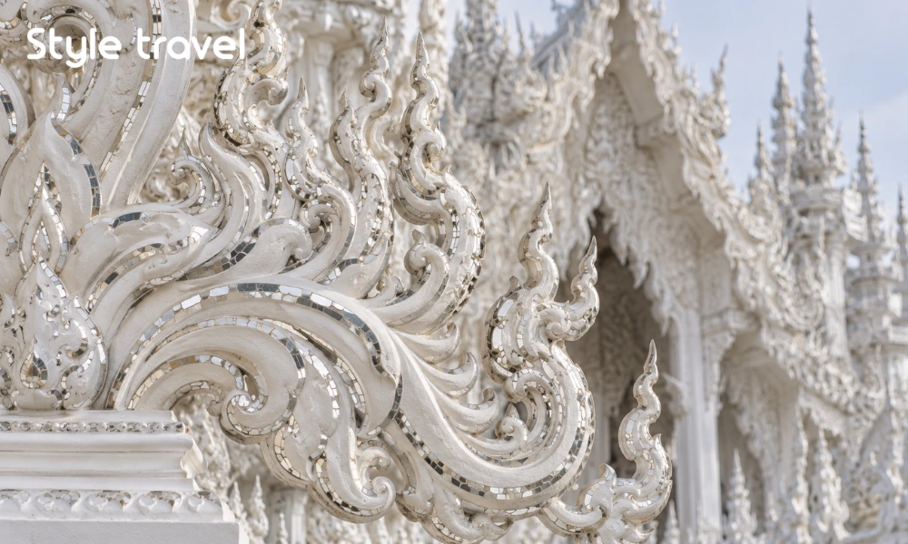 White plaster ornaments and mirrored glass details at Wat Rong Khun